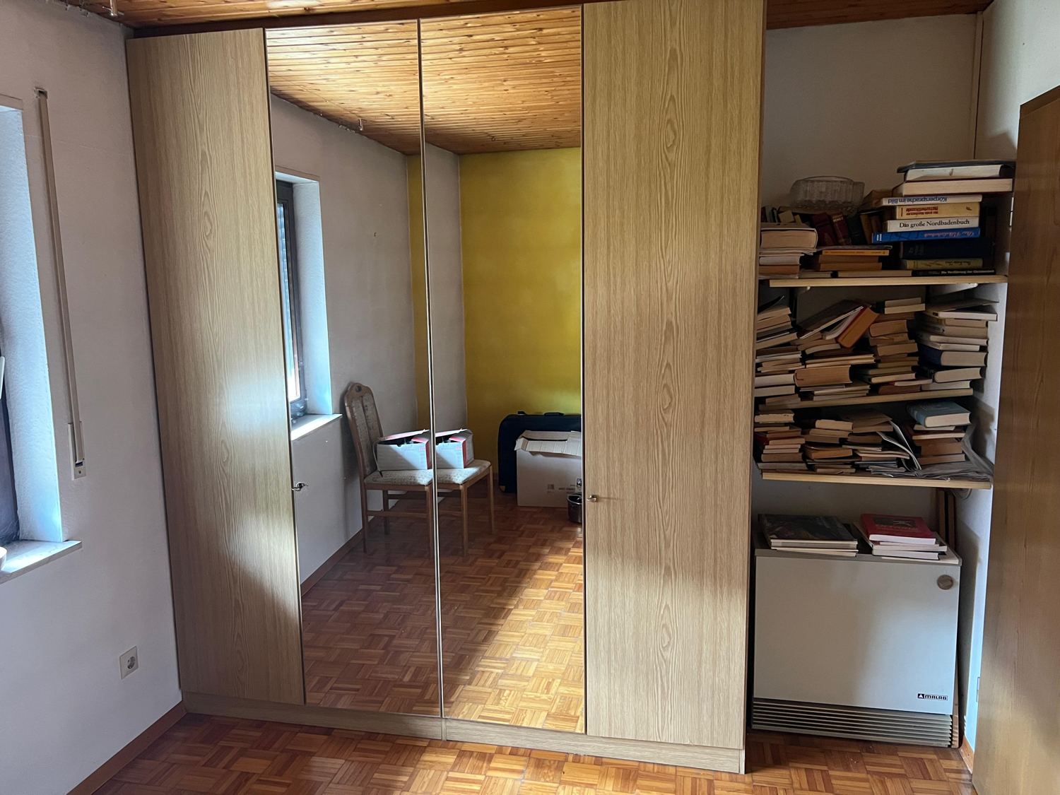 Schlafzimmer mit Schrankwand vor der Entrümpelung